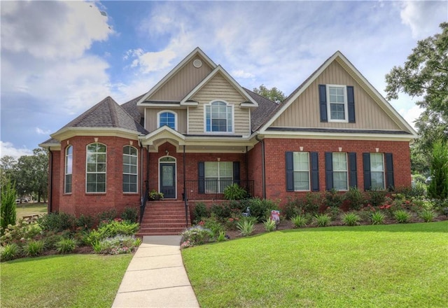 view of front facade featuring brick siding, a front lawn, and a porch