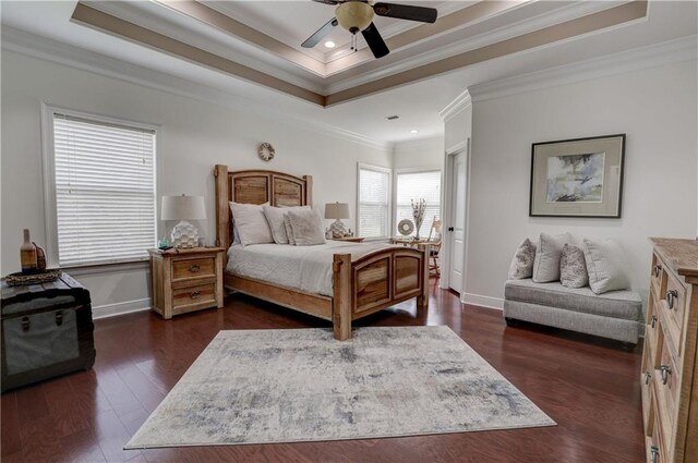 bedroom featuring a tray ceiling, dark hardwood / wood-style flooring, ornamental molding, and ceiling fan