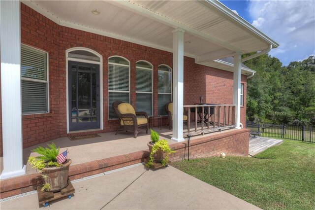 entrance to property with a porch and a lawn