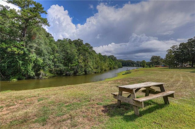 view of property's community featuring a water view and a lawn