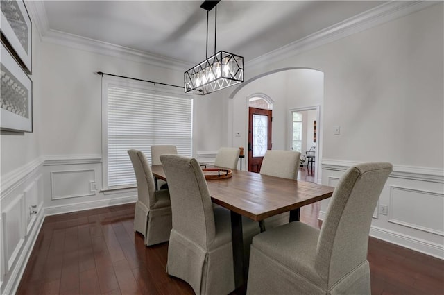 dining space with dark hardwood / wood-style floors, a notable chandelier, and ornamental molding