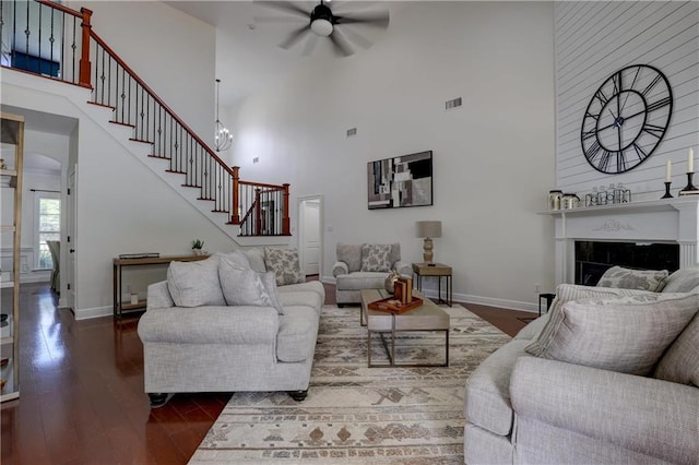 living room featuring a high ceiling, ceiling fan, and dark wood-type flooring