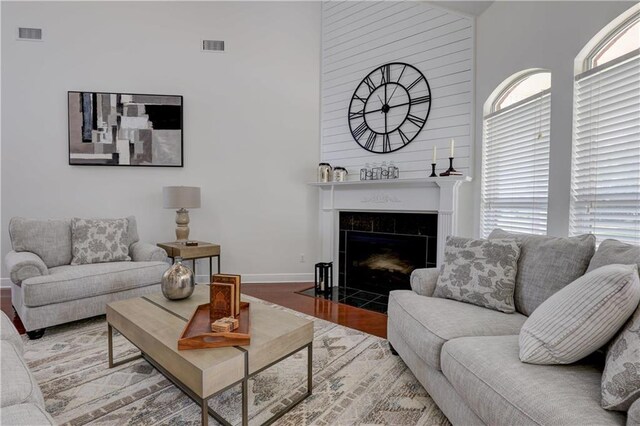 living room featuring lofted ceiling, hardwood / wood-style floors, a wealth of natural light, and a fireplace