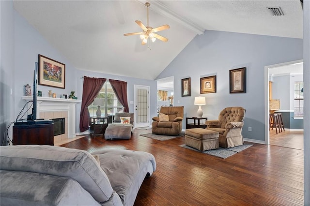12601 Deer Ridge Dr, Wilmer, AL 36587 - living room with a ceiling fan, beam ceiling, wood-type flooring, a tiled fireplace, and high vaulted ceiling