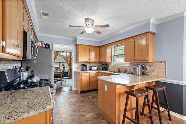 12601 Deer Ridge Dr, Wilmer, AL 36587 - kitchen with appliances with stainless steel finishes, a peninsula, ceiling fan, backsplash, and a textured ceiling