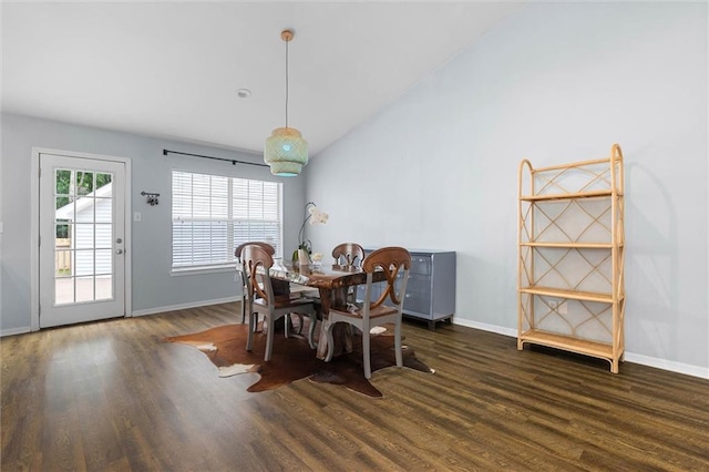 dining space featuring wood finished floors, baseboards, and vaulted ceiling