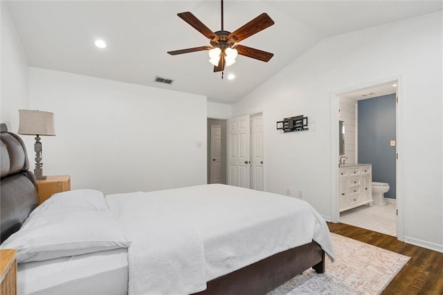 bedroom with lofted ceiling, dark wood-style floors, connected bathroom, recessed lighting, and baseboards