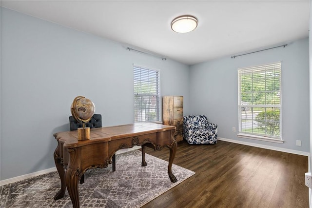 office space with plenty of natural light, baseboards, and dark wood-style flooring