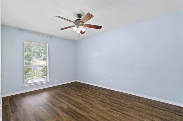 spare room with dark wood-type flooring, baseboards, and a ceiling fan