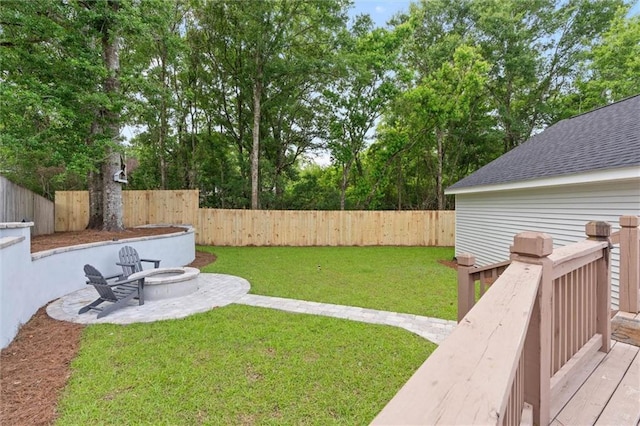 view of yard with an outdoor fire pit, a wooden deck, and a patio