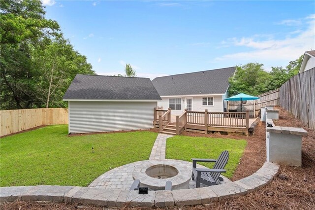 back of house featuring an outdoor fire pit, a deck, a patio, and a shingled roof