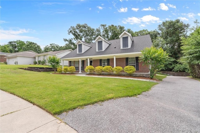 cape cod home featuring brick siding and driveway