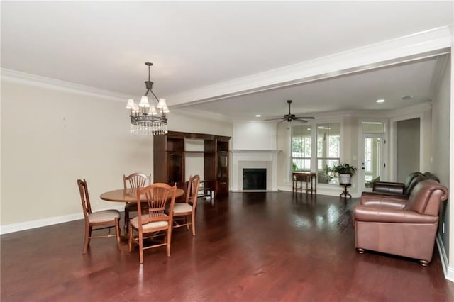 dining space with dark wood-type flooring, ceiling fan with notable chandelier, and crown molding