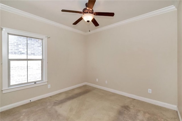 empty room featuring light carpet, a ceiling fan, baseboards, and crown molding