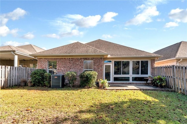 back of house with a patio, central AC unit, a fenced backyard, brick siding, and a yard