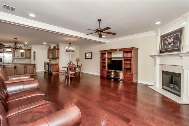 living area featuring visible vents, dark wood finished floors, ornamental molding, a fireplace, and ceiling fan with notable chandelier