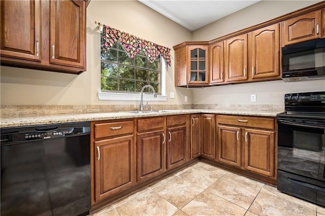 2000 Riverview Ave, Mobile, AL 36605 - kitchen featuring black appliances, a sink, brown cabinets, glass insert cabinets, and light tile patterned floors