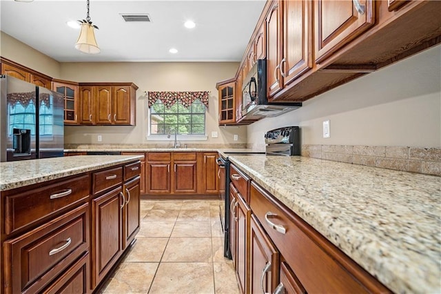2000 Riverview Ave, Mobile, AL 36605 - kitchen with black appliances, glass insert cabinets, recessed lighting, hanging light fixtures, and light stone countertops