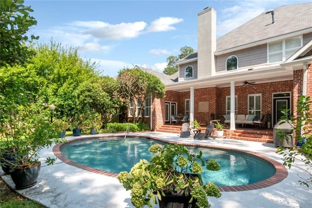 outdoor pool with a patio area and ceiling fan