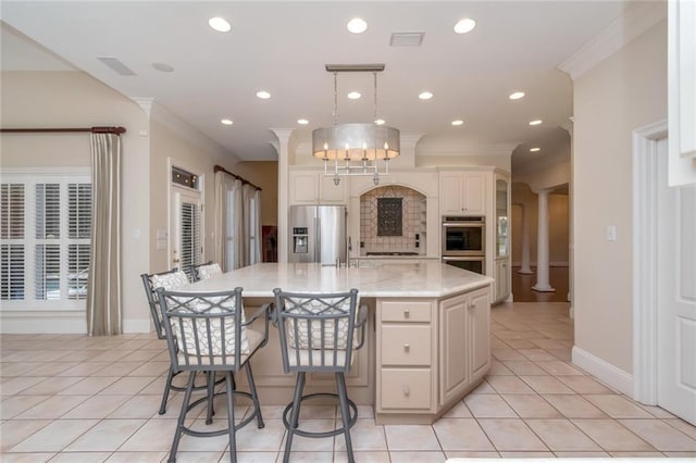 kitchen with ornate columns, crown molding, visible vents, and appliances with stainless steel finishes