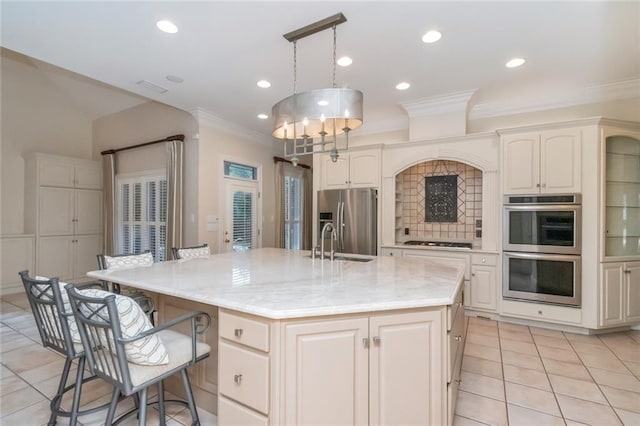 kitchen featuring a breakfast bar area, a spacious island, a sink, appliances with stainless steel finishes, and crown molding