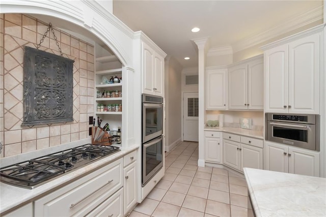 kitchen featuring appliances with stainless steel finishes, white cabinets, and light countertops