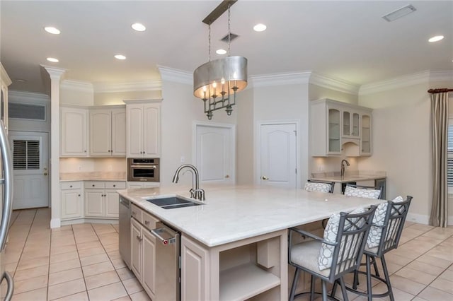 kitchen with visible vents, an island with sink, a sink, appliances with stainless steel finishes, and light tile patterned flooring