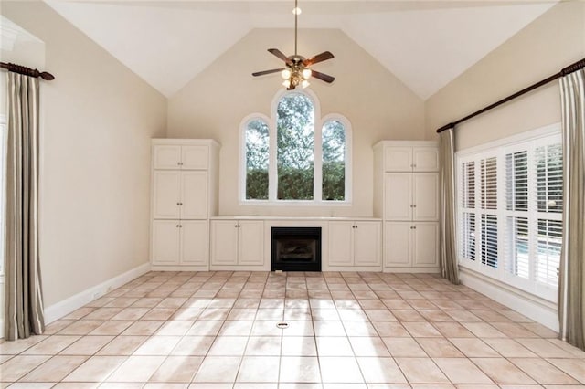 unfurnished living room with a ceiling fan, plenty of natural light, a fireplace, and light tile patterned floors