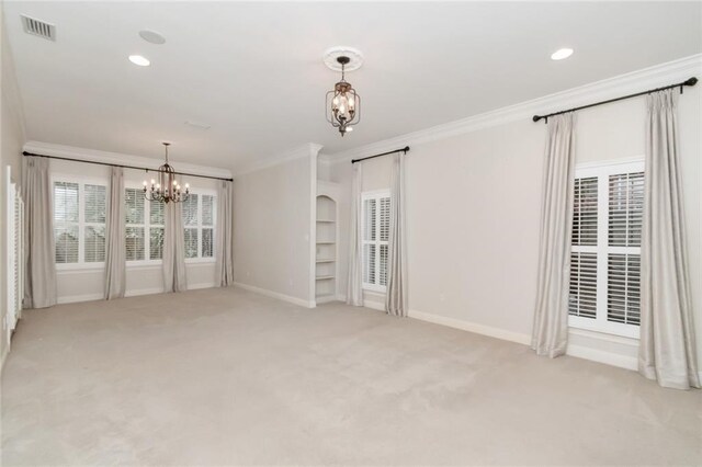 empty room with ornamental molding, a notable chandelier, visible vents, and light carpet