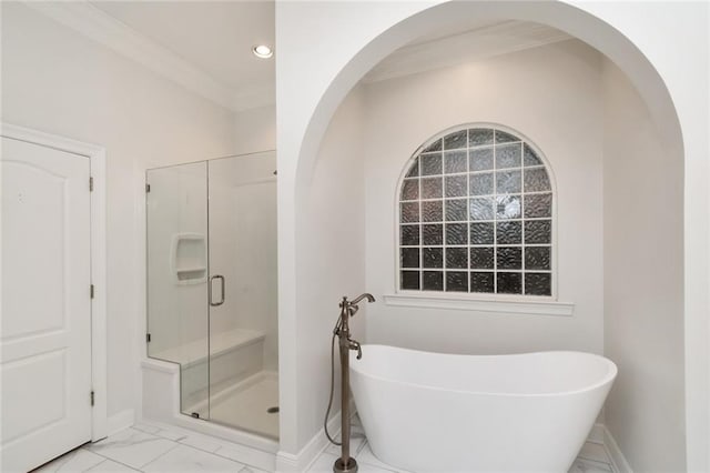 full bathroom featuring marble finish floor, ornamental molding, a shower stall, baseboards, and a soaking tub