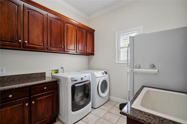 clothes washing area with washer and clothes dryer, cabinet space, crown molding, light tile patterned floors, and baseboards