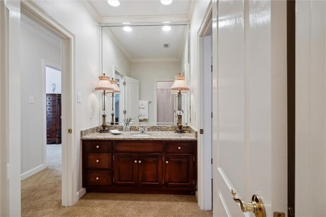 bathroom featuring visible vents, baseboards, ornamental molding, and vanity