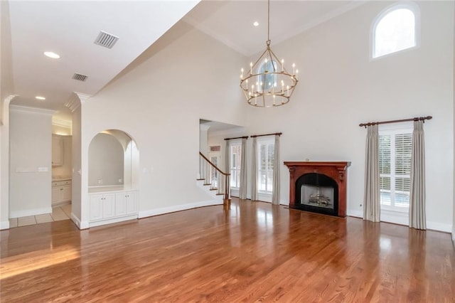 unfurnished living room featuring visible vents, a fireplace, and light wood-style floors