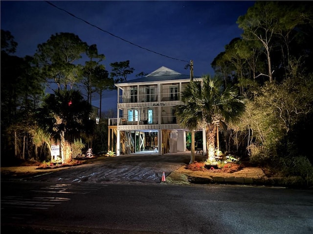 view of front of house with a carport, a balcony, and driveway