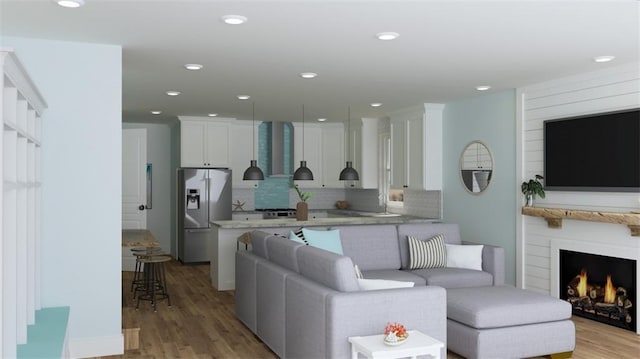 living room featuring light wood-style floors, recessed lighting, and a lit fireplace