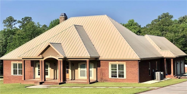 view of front of property featuring central AC and a front yard