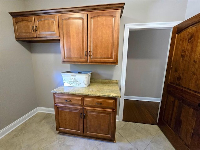 kitchen featuring light tile patterned flooring and light stone countertops