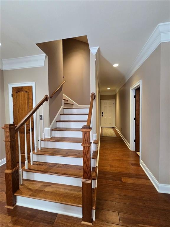 stairs with wood-type flooring and ornamental molding