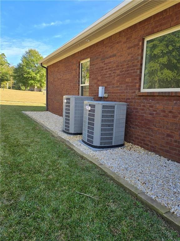 view of home's exterior featuring central AC unit and a yard