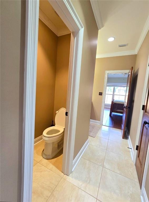 bathroom featuring tile patterned floors, toilet, and crown molding