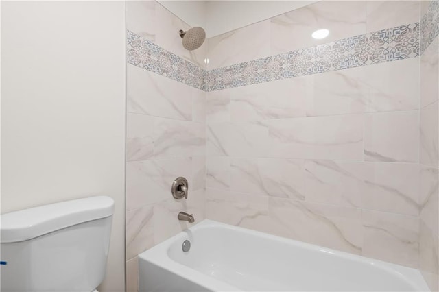 bathroom featuring toilet and tiled shower / bath