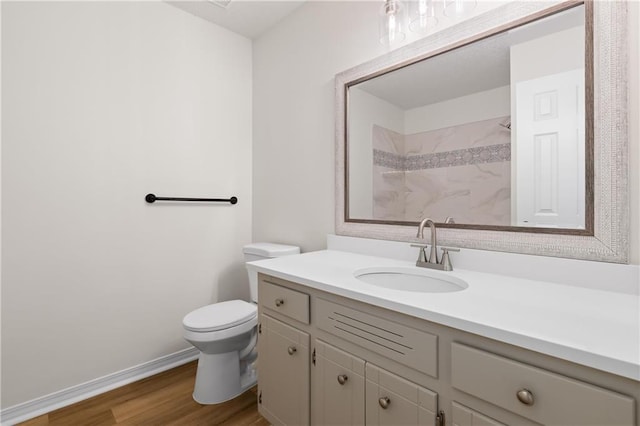 bathroom with toilet, hardwood / wood-style flooring, and vanity