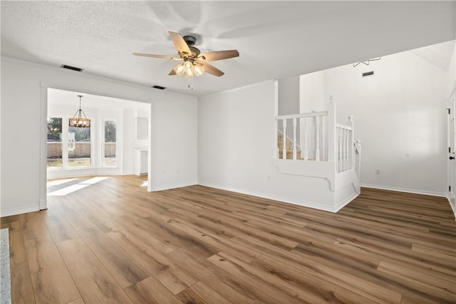 interior space featuring a textured ceiling, crown molding, ceiling fan with notable chandelier, and hardwood / wood-style flooring