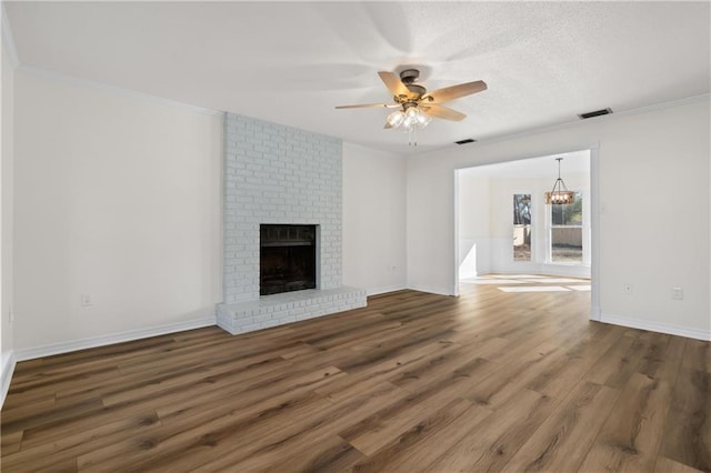 unfurnished living room with ceiling fan, a fireplace, crown molding, a textured ceiling, and dark hardwood / wood-style flooring