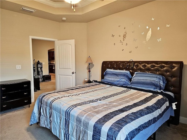 bedroom featuring light carpet, visible vents, and a raised ceiling