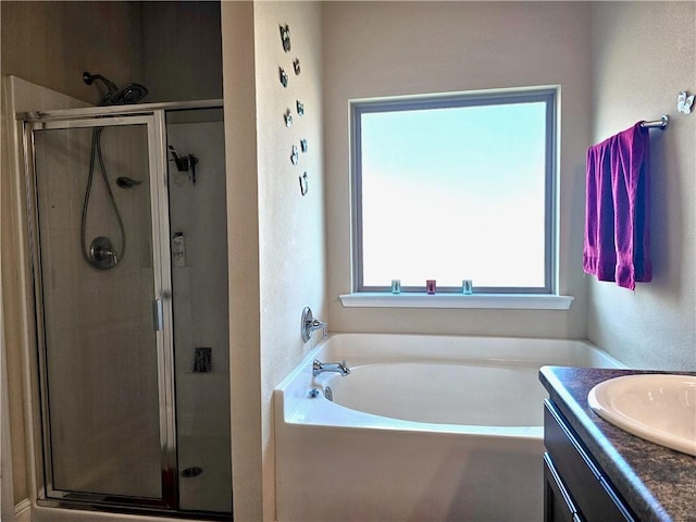 full bathroom with a bath, vanity, a textured wall, and a shower stall