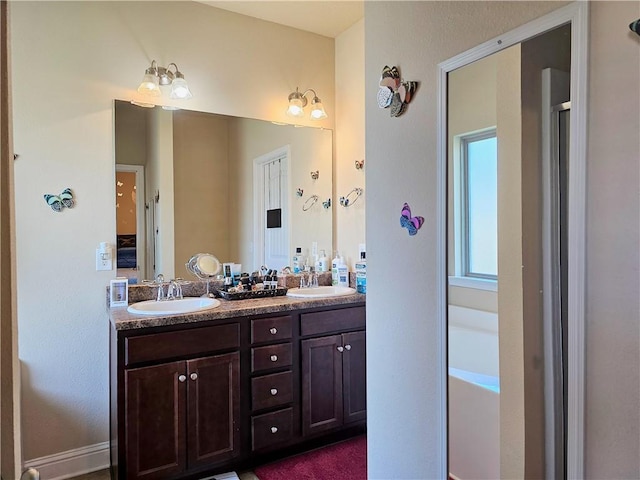 full bathroom featuring double vanity, a sink, and a bathtub