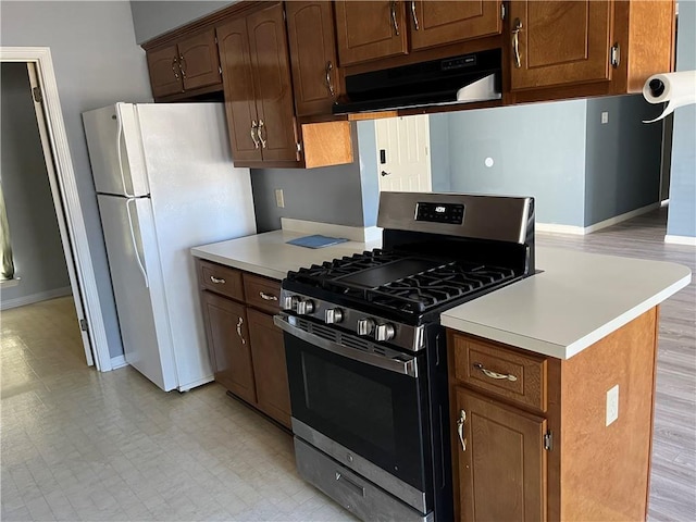 kitchen with gas range and white refrigerator