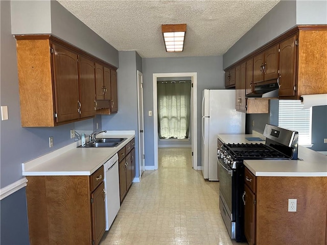 kitchen with white appliances, sink, and a textured ceiling