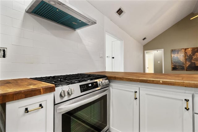 kitchen featuring stainless steel range with gas cooktop, custom exhaust hood, visible vents, vaulted ceiling, and butcher block countertops